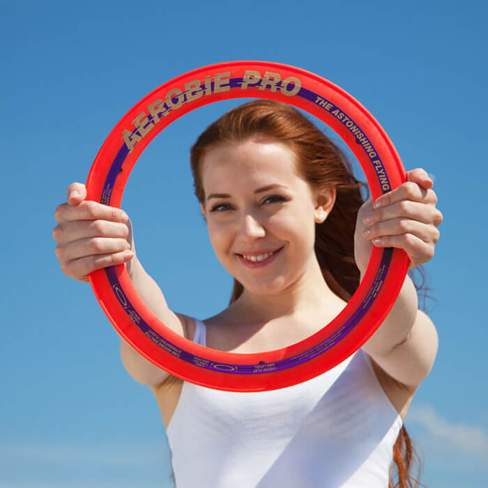 Aerobie - Mädchen hält roten Pro Ring in den Händen Aerobie - Mädchen hält roten Pro Ring in den Händen