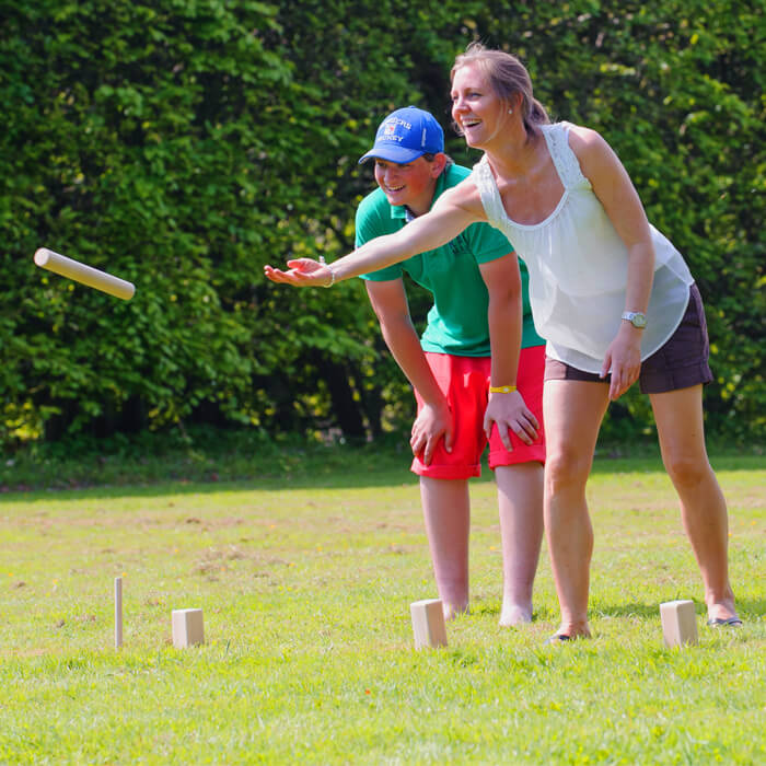Aerobie - Junge und Frau spielen auf der Wiese Spiel mit Holzfiguren Aerobie - Junge und Frau spielen auf der Wiese Spiel mit Holzfiguren