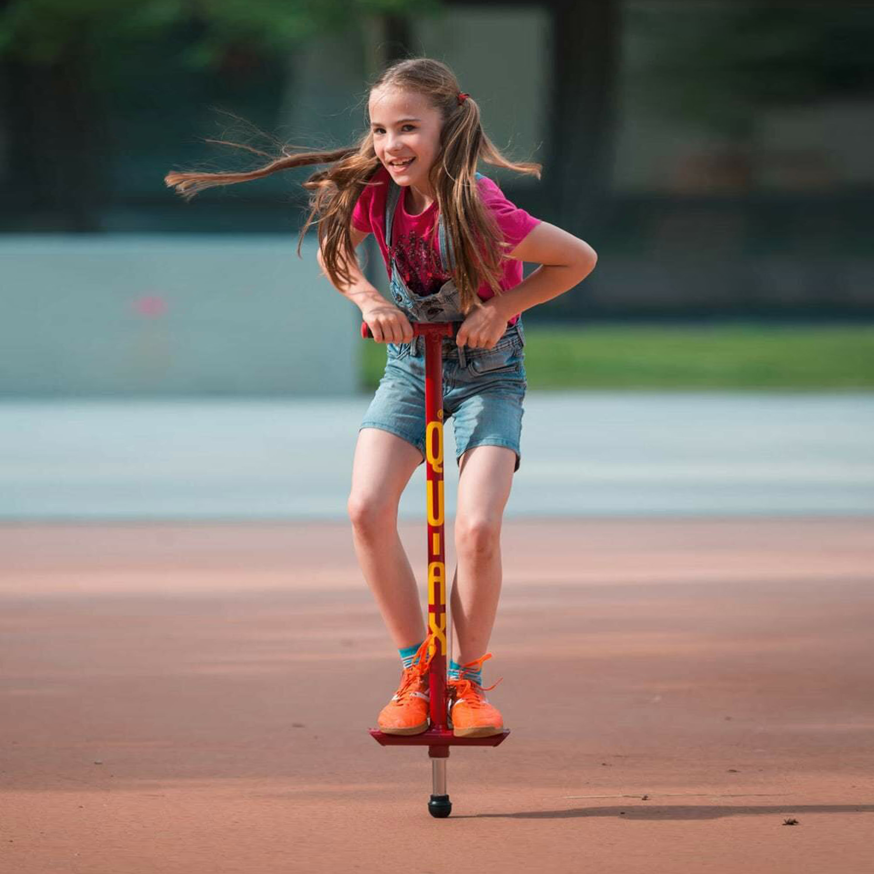 Maedchen mit rotem QU-AX-Pogo-Stick Hüpfstick auf dem Spielplatz draußen Hüpfstab von QU-AX-Pogo-Stick in rot bis 30kg, 100cm lang online kaufen!